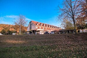 A hotel with a large building, multiple windows, and a sloped roof.