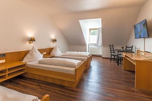 A room with two beds, a desk, a chair, and a television. - Bartholomäus (Zeitlarn)