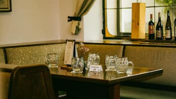 Ein Restaurantinneres mit einem Holztisch, mehreren Weinflaschen und einem Menüständer.