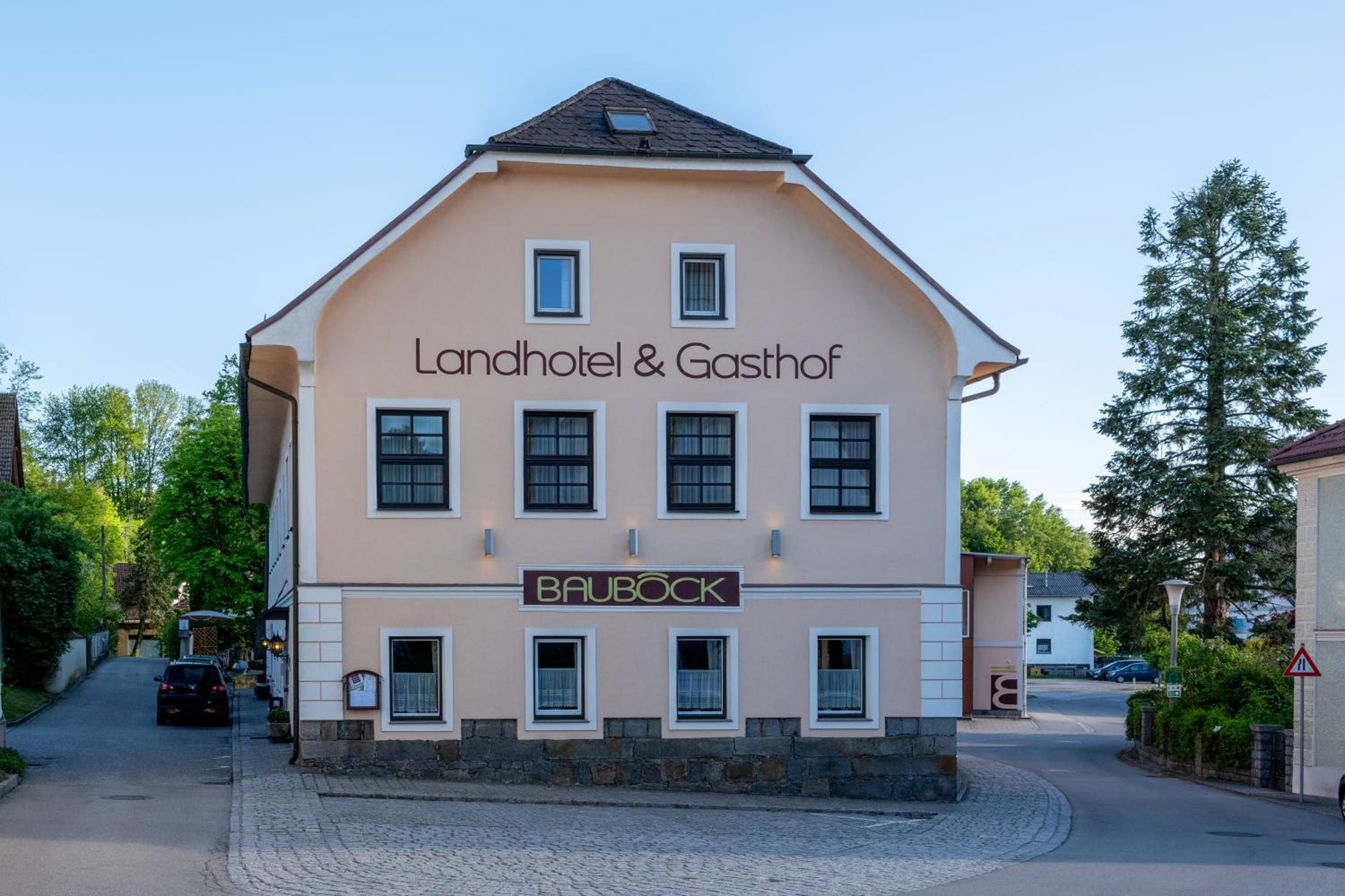 Ein zweistöckiges Gebäude mit einem Schild für 'Landhotel & Gasthof' und 'BAUBOCK'.