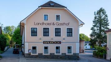 Ein zweistöckiges Gebäude mit einem Schild für 'Landhotel & Gasthof' und 'BAUBOCK'.