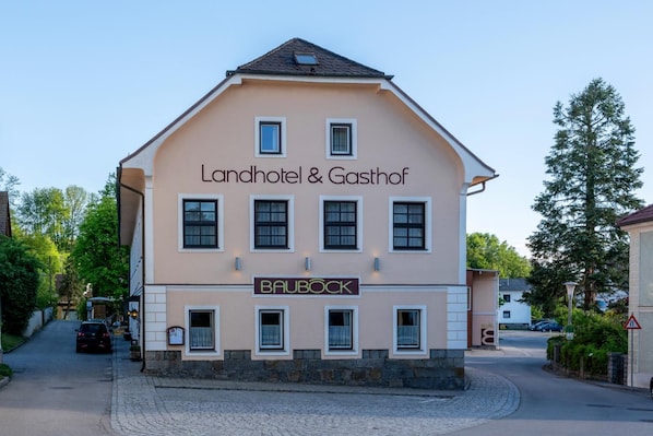 A two-story building with a sign for 'Landhotel & Gasthof' and 'BAUBOCK'.