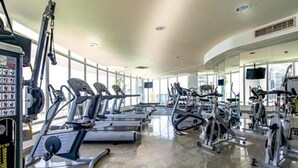 Un gimnasio con cintas de correr, bicicletas estáticas y máquinas de pesas.