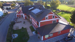 A red building with a sign reading "Hotel Gräbinger" and a parking lot. - Hotel Grabinger (Schwandorf)