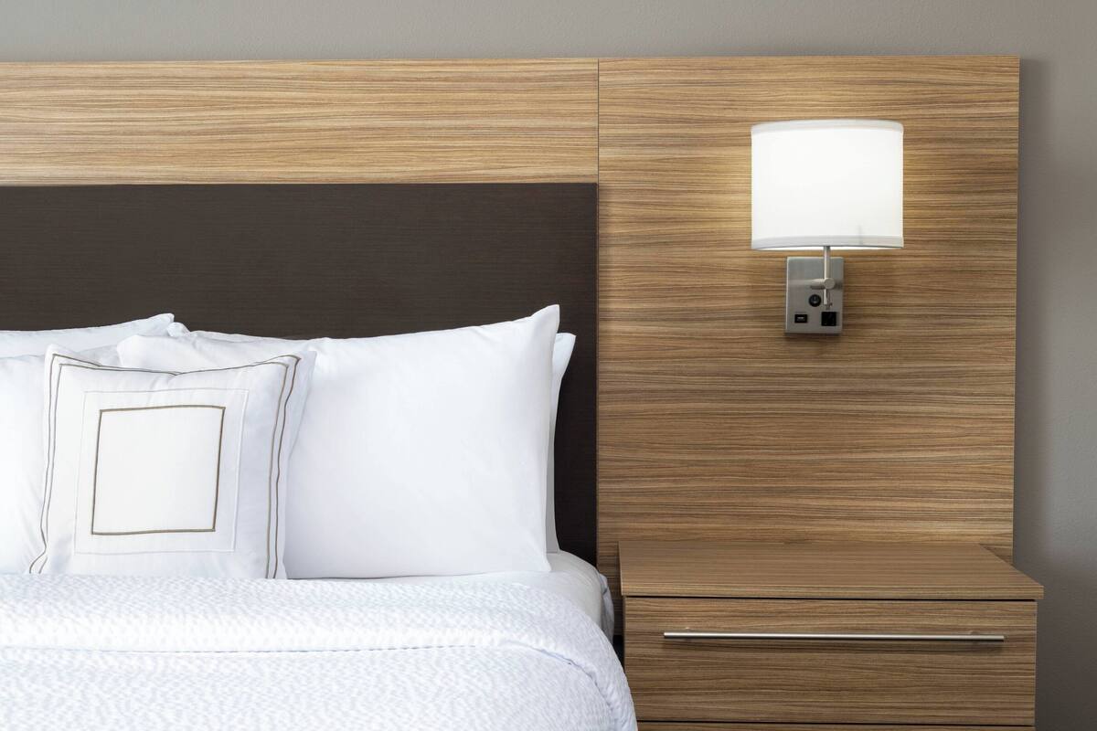 Escritorio, cortinas opacas, tabla de planchar con plancha