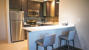 A modern kitchen with stainless steel appliances, a large island, and bar stools. - Residence Inn by Marriott Phoenix Mesa East (Mesa)