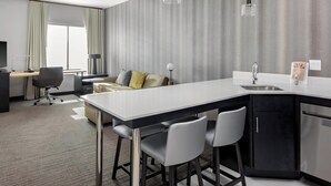 A modern hotel room with a large kitchen area, a sofa, and a desk. - Residence Inn by Marriott Phoenix Mesa East (Mesa)
