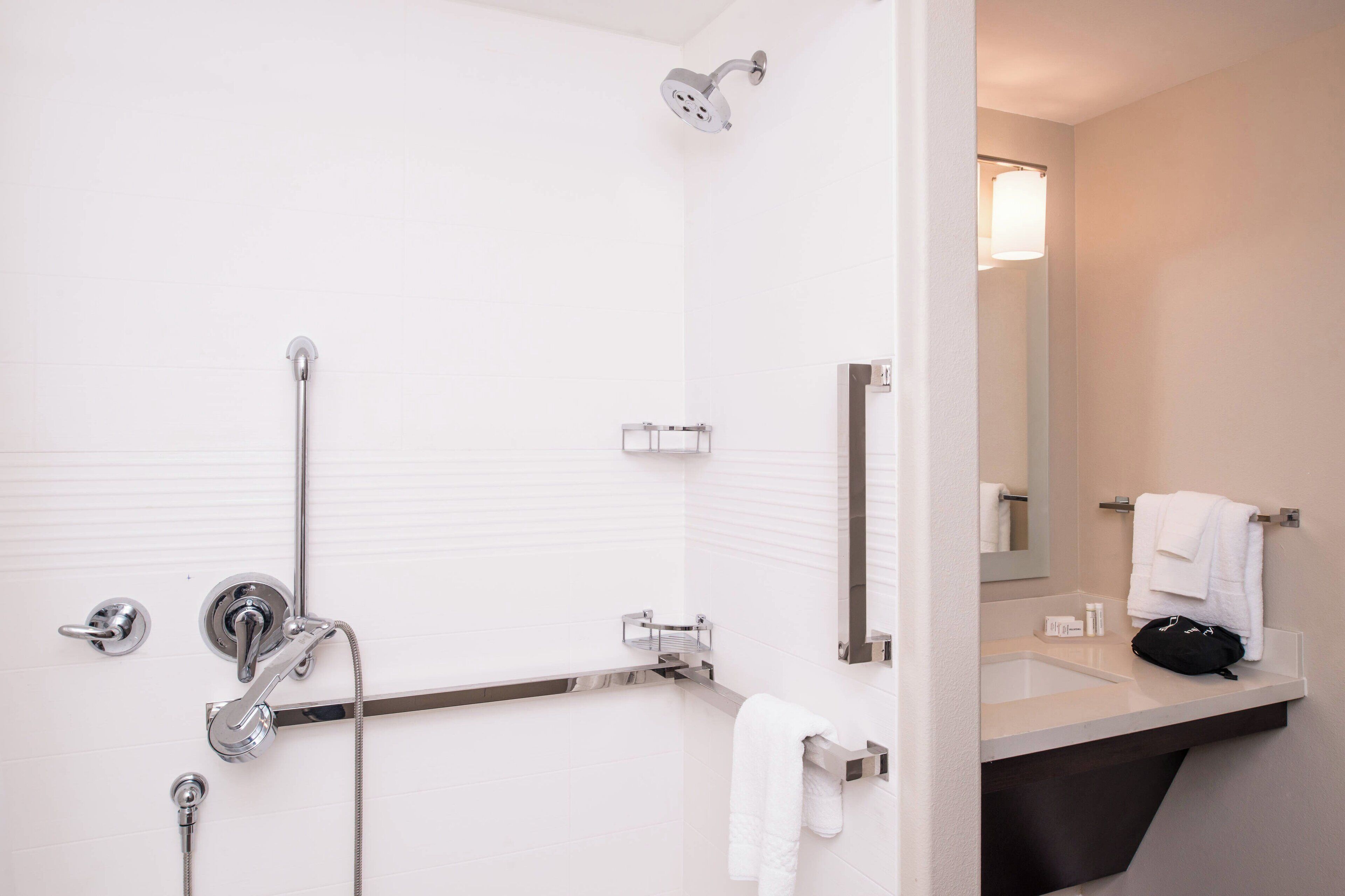 Ein modernes Badezimmer mit Dusche, Waschbecken und Spiegel.