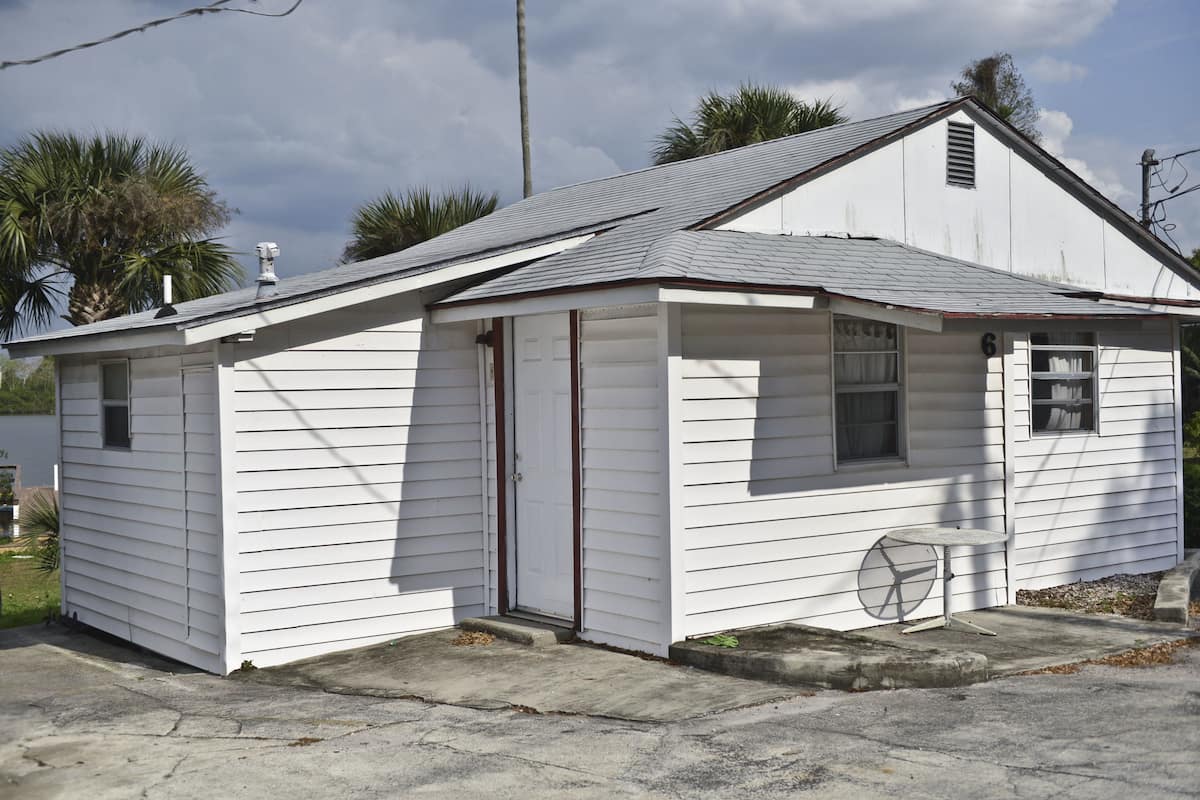 A small, single-story white building with a gabled roof and a small porch area.