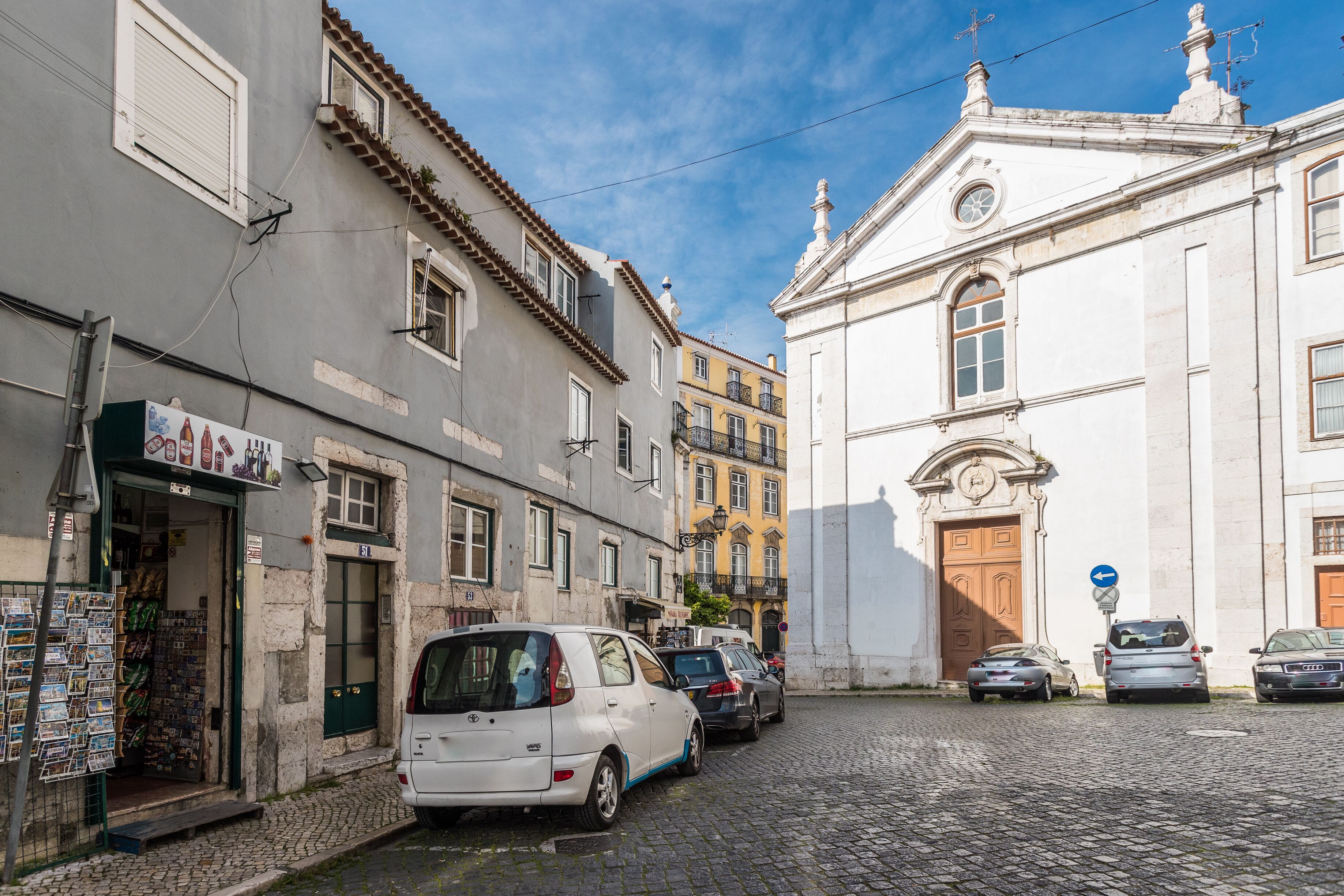 Una calle empedrada flanqueada por edificios históricos, entre ellos una iglesia con una entrada destacada.