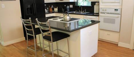 Refrigerador em uma área comum, micro-ondas em uma área comum, cooktop