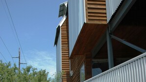 Een modern gebouw met twee verdiepingen, een overdekt buitengebied en een trap naar de ingang.