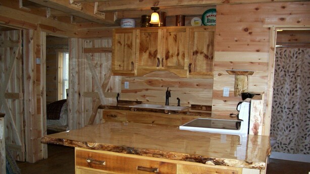 Una cocina de madera con una isla central, armarios y un lavamanos.