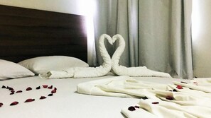 A hotel room with a bed, white pillows, and a heart-shaped towel arrangement on the bed. - Hotel Pousada WS (Ipojuca)