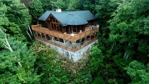Une cabane en bois dotée d’un balcon, entourée d’une forêt dense.