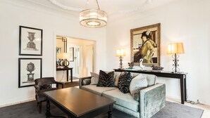 A living room with a sofa, coffee table, and a console table with lamps and decorative items.