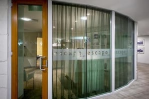 A modern hotel entrance with a glass door and a sign reading "Escape."