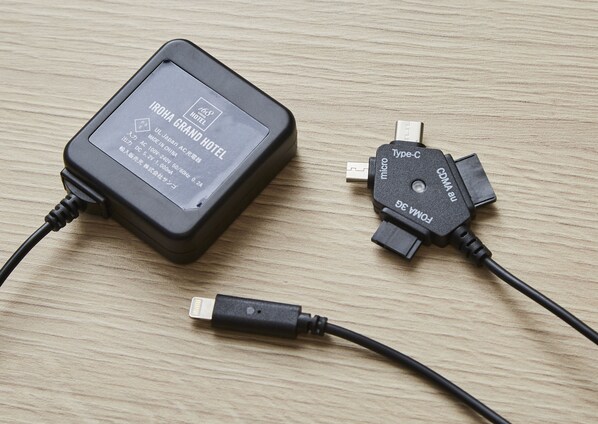 A power adapter with a label indicating it is for the IROHA GRAND HOTEL, made in China, and has a 50/60Hz, 1,000W output. - Iroha Grand Hotel (Matsumoto)