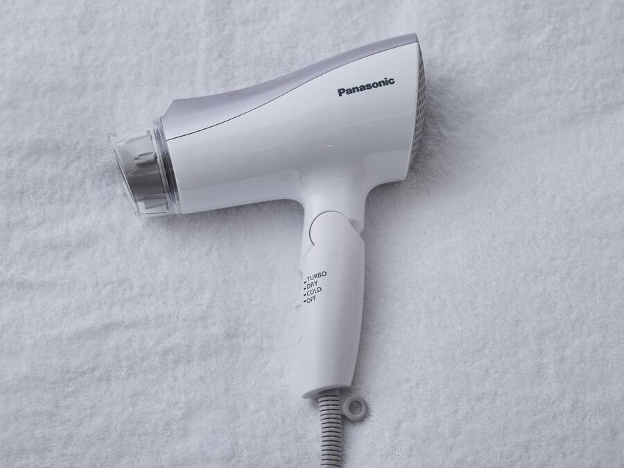 En hårfön från Panasonic med ett tydligt munstycke och en strömkabel.