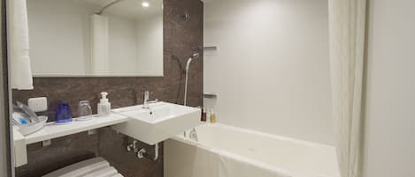 Un baño moderno con una bañera, un lavabo y un inodoro.