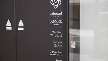 A black door with white text and symbols indicating a wedding, banquet, convention, and event services.