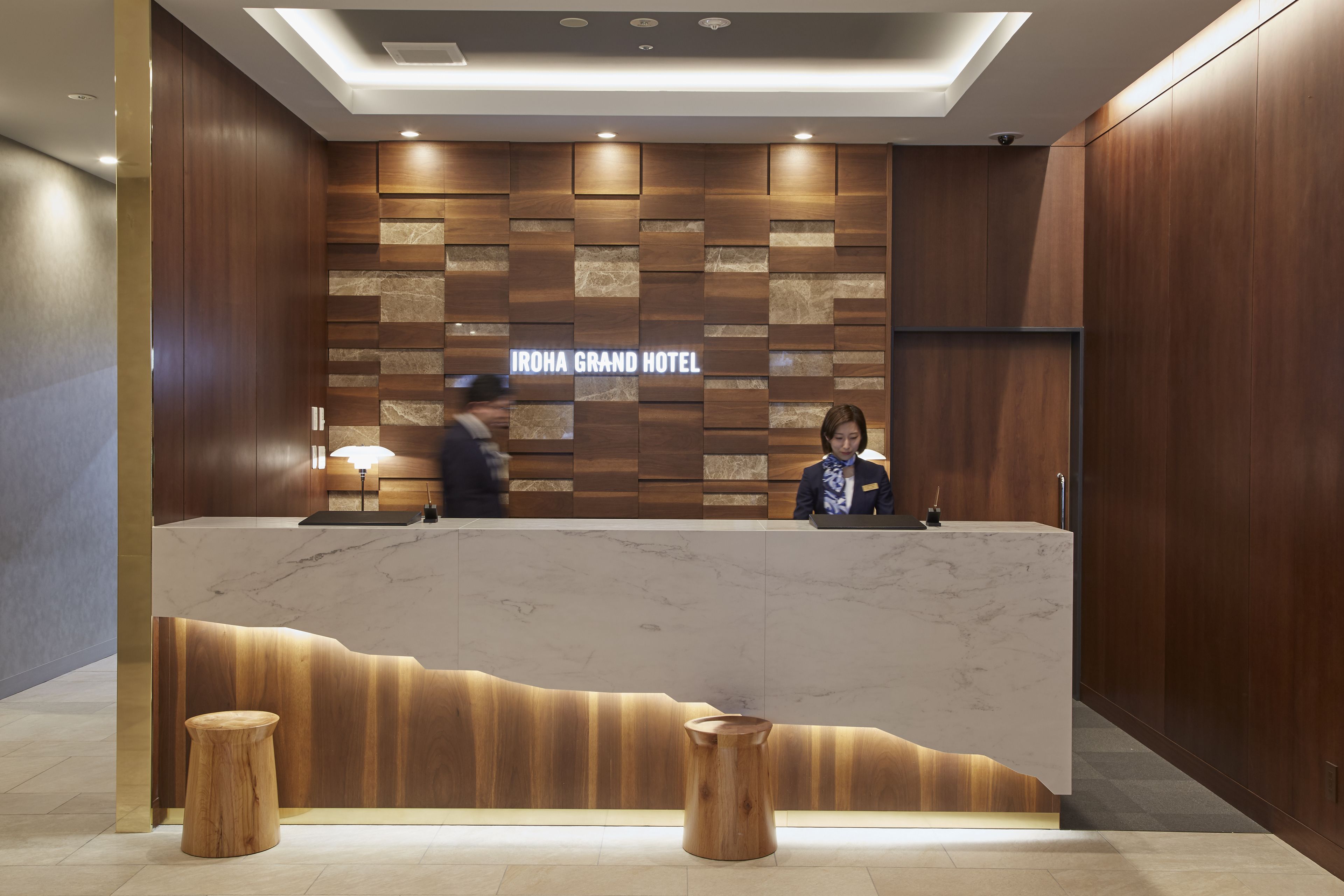 Una recepción con diseño de paneles de madera y mostrador de mármol.