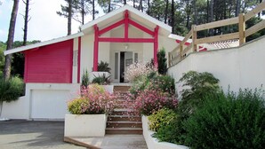 A building with a red and white facade, a staircase leading to the entrance, and a wooden fence.