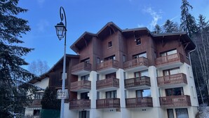 Un edificio a più piani con balconi in legno e un cartello che indica parcheggio privato.