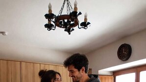 A kitchen with wooden cabinets, a granite countertop, a sink, and a window with a view. - Galician Stone Cottage for 2 people  (A Coruna)