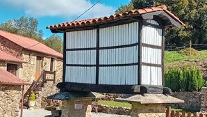 A stone structure with a tiled roof, a wooden staircase, and a stone wall. - Galician Stone Cottage for 2 people  (A Coruna)