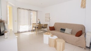 A modern living room with a sofa, coffee table, and dining area. - A110 EDIFICIO LA REINA 8º 45 (Calpe)