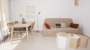 A minimalist living room with a beige sofa, a wooden dining table, and a white coffee table. - A110 EDIFICIO LA REINA 8º 45 (Calpe)