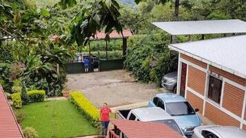 Zona residenziale con una casa verde, un piccolo giardino e auto parcheggiate.