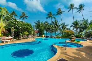 A resort pool area with multiple swimming pools, lounge chairs, and palm trees. - Magical, 2 Bedroom Apartment in Beachside Complex (Koh Samui)
