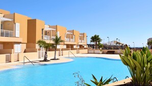 A swimming pool surrounded by a building with balconies and palm trees. - BALCONY TO THE SEA, HOLIDAY APARTMENT - PORÍS 8 (Porís de Abona)