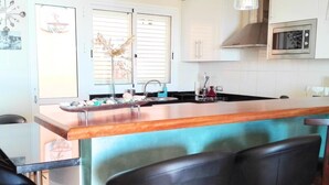 A kitchen with a bar area, a sink, and a microwave. - BALCONY TO THE SEA, HOLIDAY APARTMENT - PORÍS 8 (Porís de Abona)