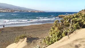 A beach with clear blue water, a rocky shoreline, and sparse vegetation. - BALCONY TO THE SEA, HOLIDAY APARTMENT - PORÍS 8 (Porís de Abona)