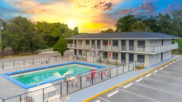 Een buitenzwembad, parasols bij het zwembad en ligstoelen