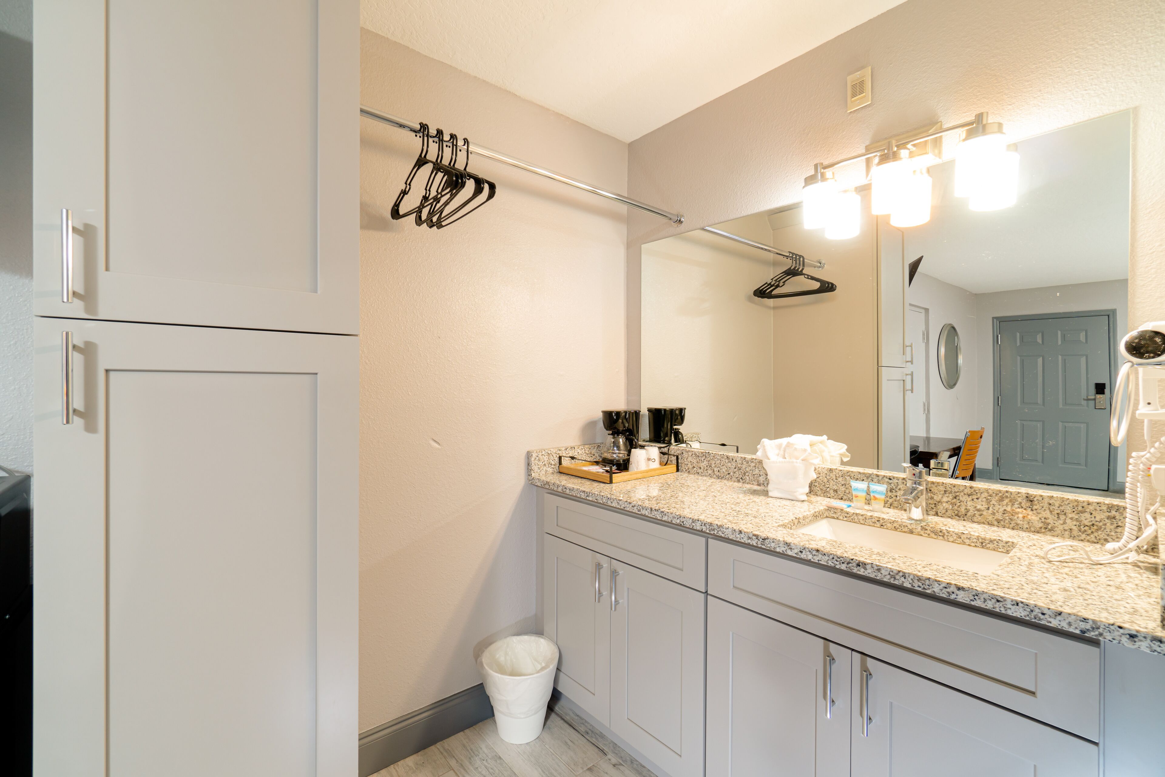A bathroom with a sink, mirror, and towel rack.