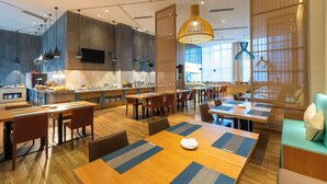 A modern dining area with wooden tables, chairs, and a central island with a kitchen. - Royce Hotel Shenzhen (Shenzhen)