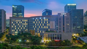 A hotel with a modern architectural design, featuring multiple floors and a prominent entrance. - Royce Hotel Shenzhen (Shenzhen)