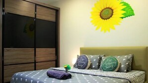 Ein Schlafzimmer mit einem Bett, einer Wanddekoration mit Sonnenblume und einem Kleiderschrank.