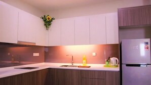 Eine moderne Küche mit Holzschränken, einer integrierten Spüle und einem Kühlschrank.