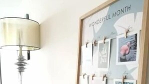 A framed collage with the text "WONDERFUL MONTH" on a wall, a lamp, a chair, and a small vase with flowers on a table. - 5 Pax Empire Soho by SYNC (Petaling Jaya)