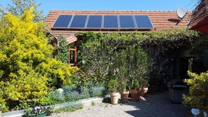 A house with a garden, solar panels, and a satellite dish.