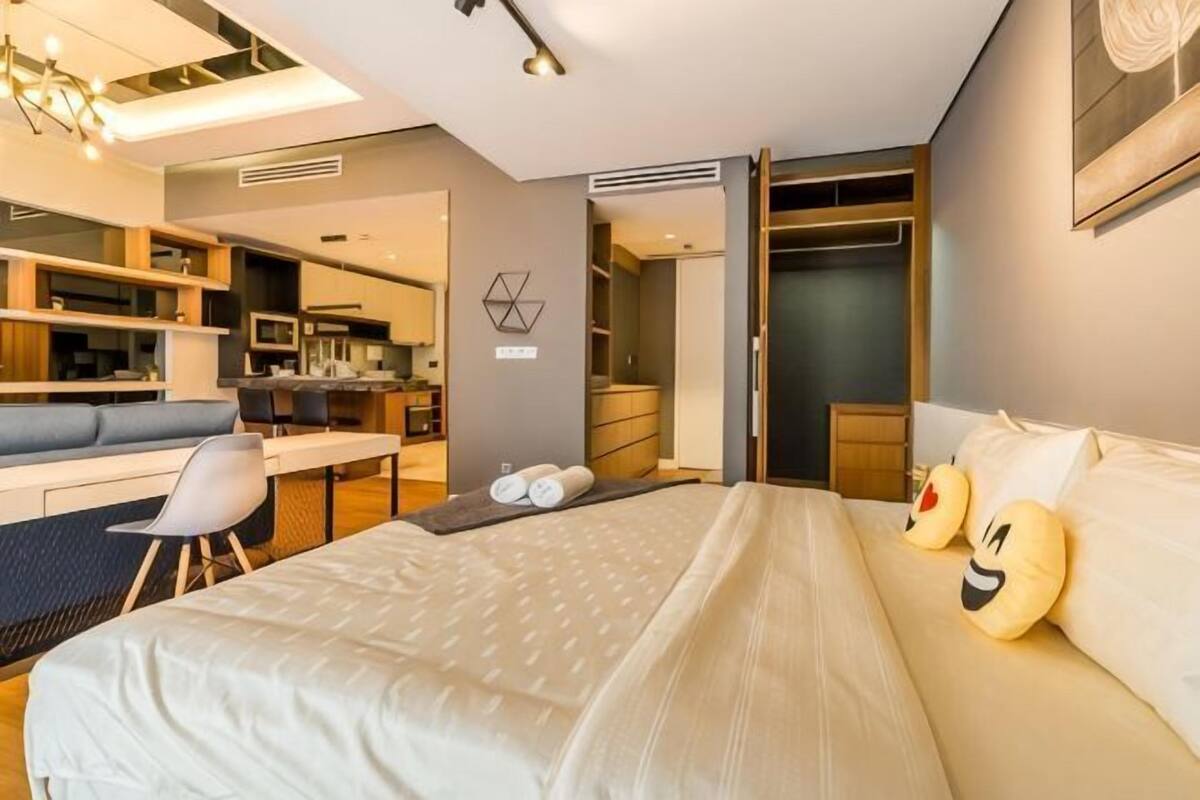 Une chambre d’hôtel moderne équipée d’un lit, d’un bureau et d’une kitchenette.