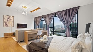 A modern hotel room with a large bed, a desk, and a view of the city. - Anggun Residences Serviced Suites (Kuala Lumpur)