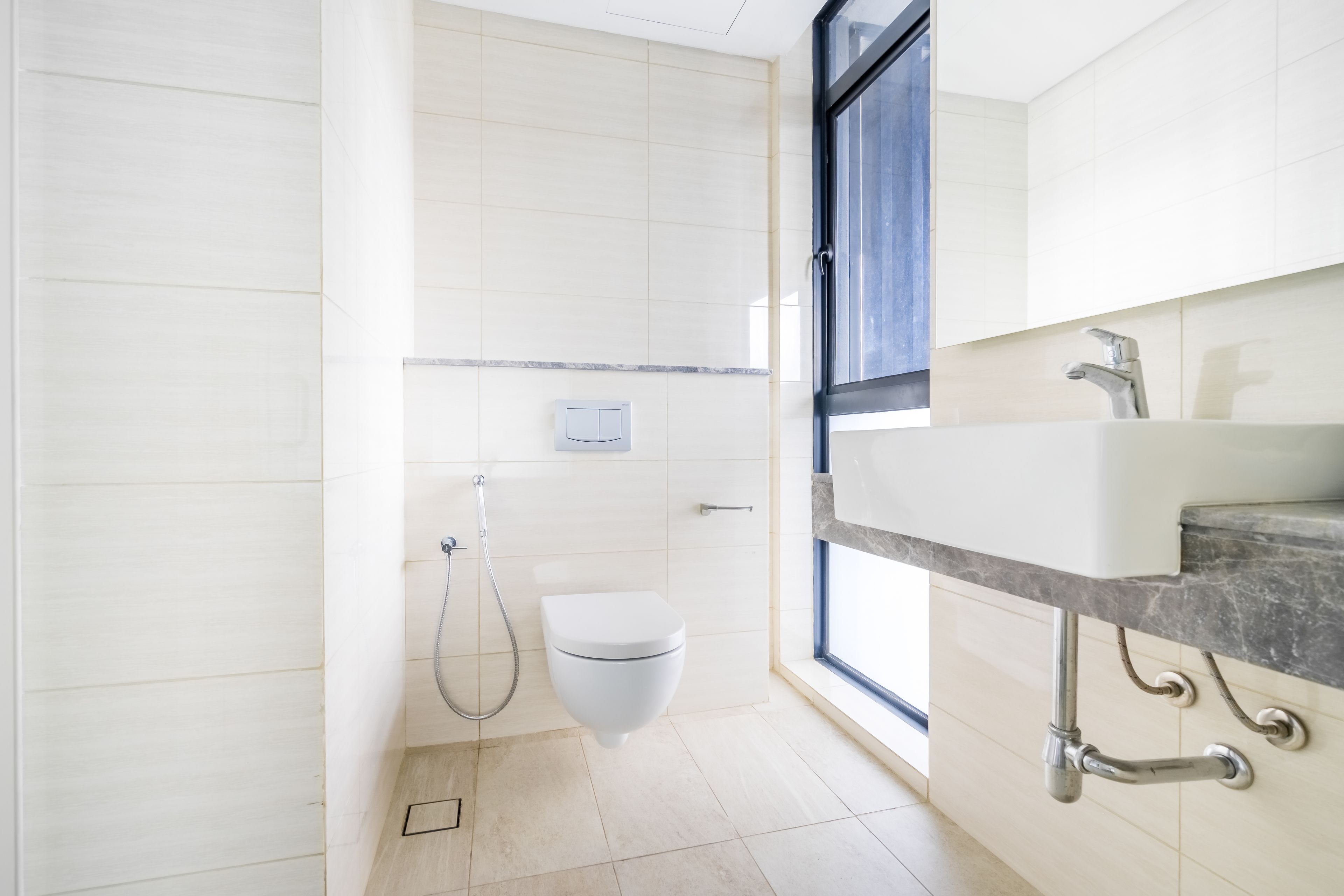 A modern bathroom with a toilet, shower, and sink.