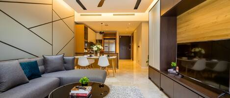 A modern living room with a grey sofa, a coffee table, and a TV on a wooden cabinet.