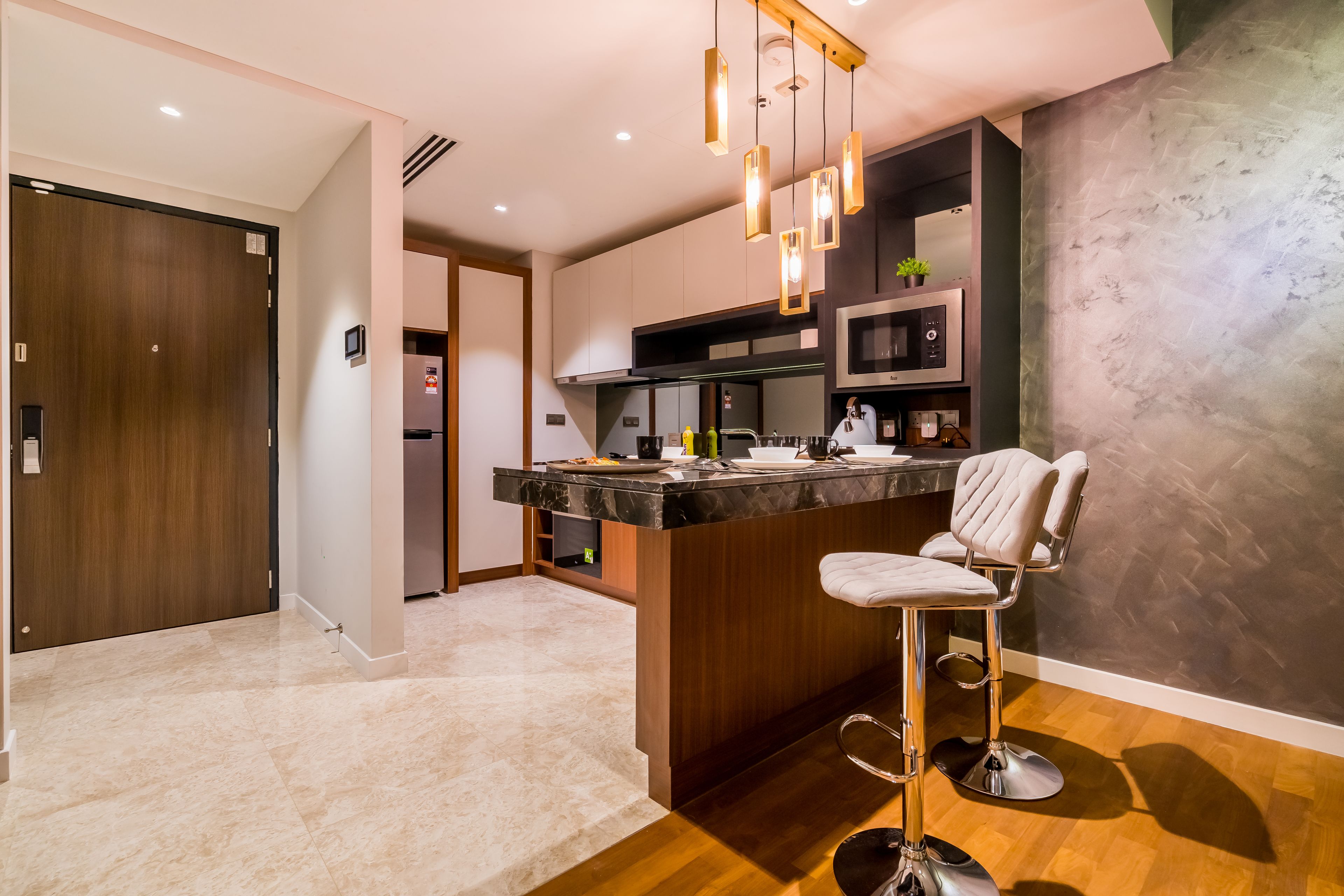 Una cocina moderna con encimera de mármol, barra con taburete y una isla grande.